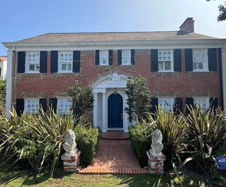 Brick colonial home with freshly painted white trim and navy shutters