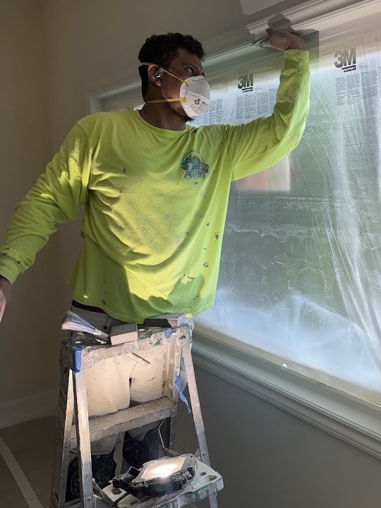 Anaya's Painting crew member masking and prepping windows